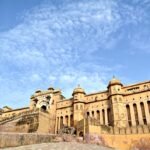 Wide exterior view of Amer Fort Jaipur under a blue sky