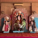 Durga idol with an ornate white backdrop and accompanying deities in Jaipur