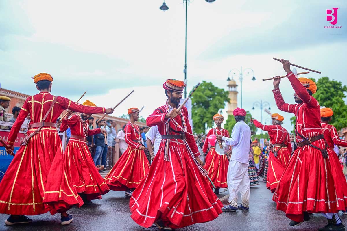 Rajasthani folk dancers performing in red costumes during Teej in Jaipur